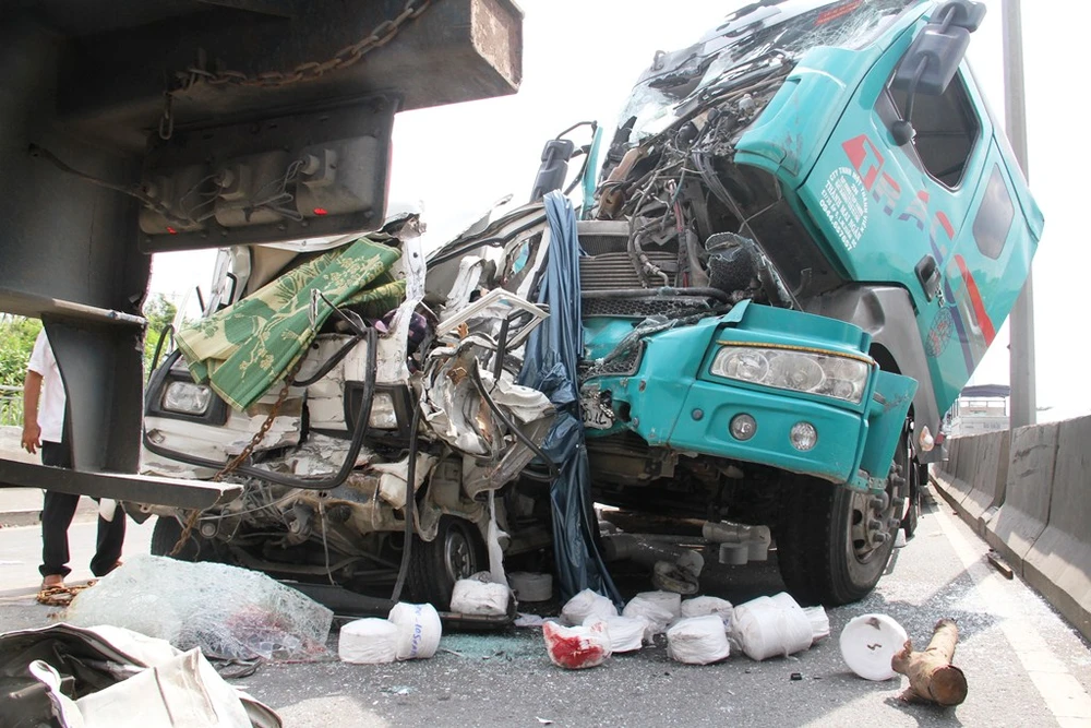 Phần đầu xe biến dạng, nhiều hàng hóa trên xe rơi vãi ra đường. 